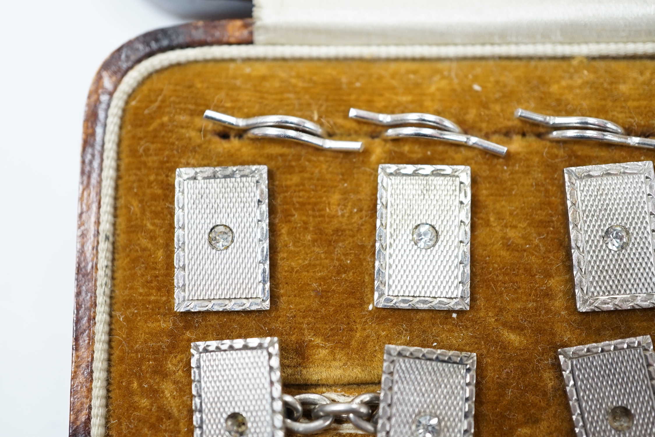 A cased George V engine turned silver and paste set eight piece dress stud set, Henry Griffith & Sons Ltd, Chester, 1934.